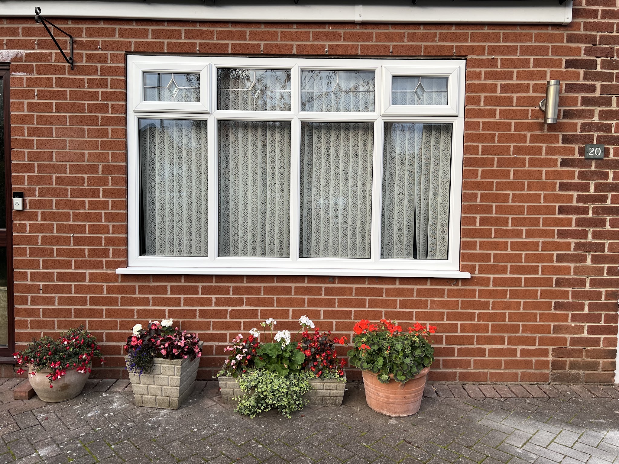 White windows with leaded top lights on a brick bungalow